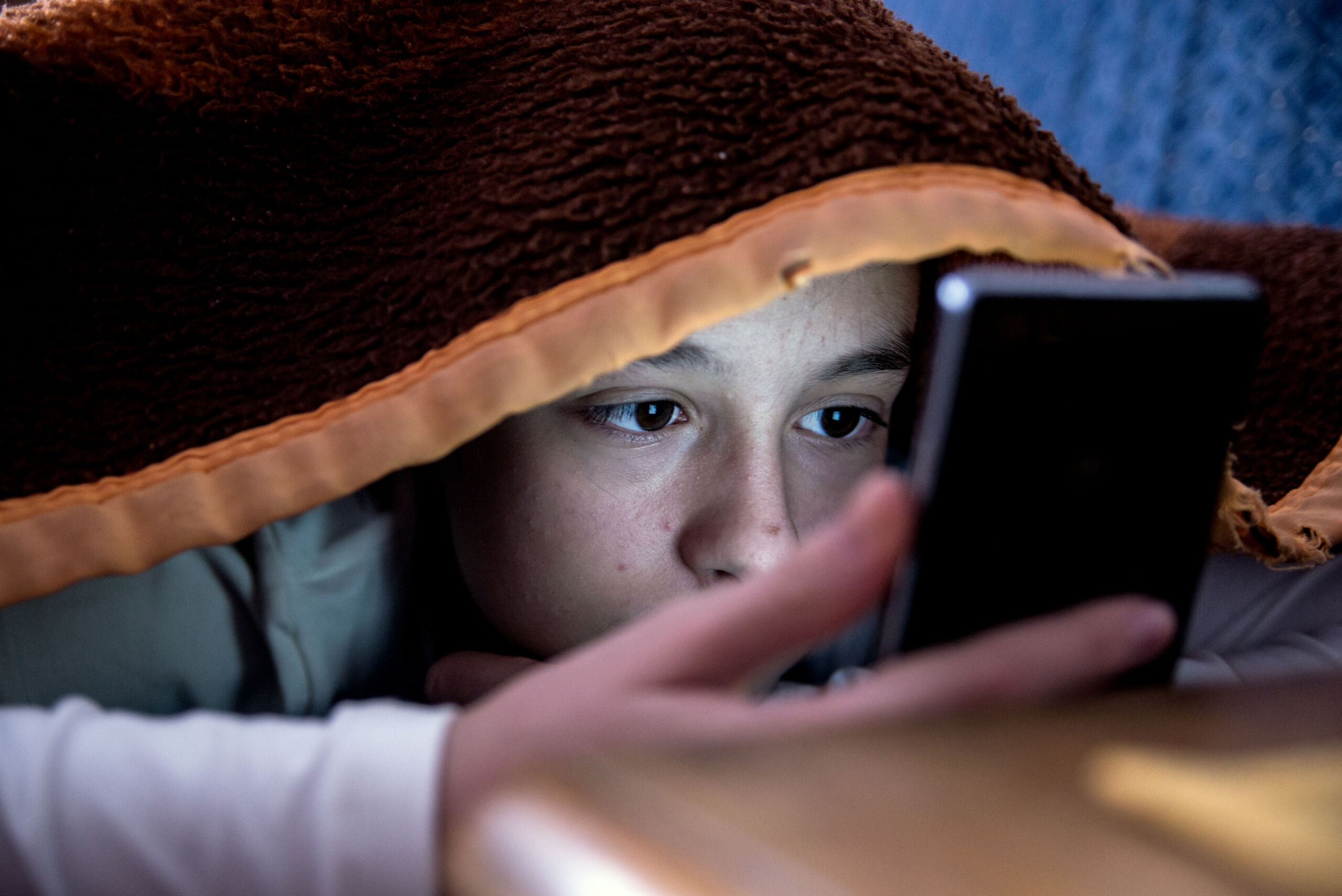 girl in bed texting on smartphone